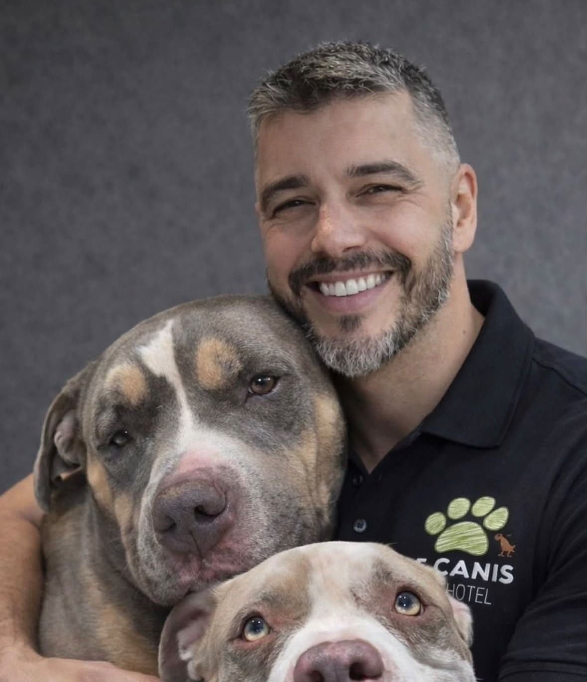 Vanderley, fundador da Le Canis, abraçado a dois cães